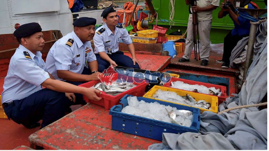 SIMON (tengah) menunjukkan sebahagian ikan dirampas daripada tiga bot nelayan Vietnam yang menangkap ikan di perairan negara. FOTO Rosli Ilham.