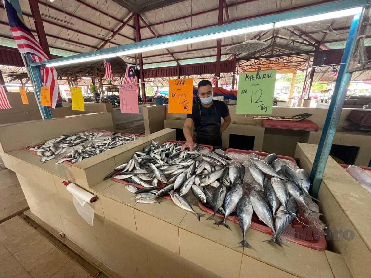 SHAHRIZAL menunjukkan tanda harga ikan terkini yang meningkat. FOTO AHMAD RABIUL ZULKIFLI