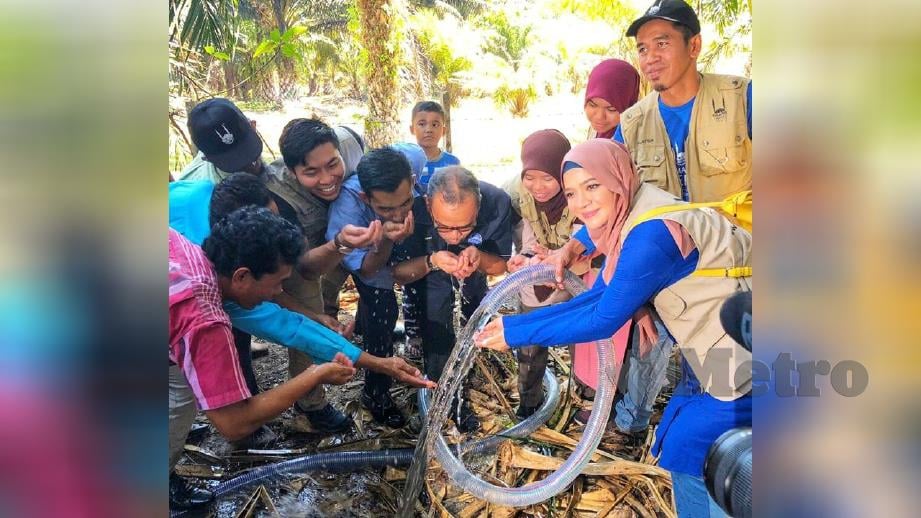 MUSA dan Ikon IRM, Diana Amir bersama wakil IRM dan penduduk kampung mencuba air bersih dari Projek Aqua. FOTO Ihsan USIM 