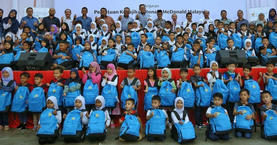 MURID-murid yang menerima Pek Kembali Ke Sekolah pada Majlis Penyerahan Pek Kembali Ke Sekolah Sumbangan Yayasan Jaafar Ahmad Anjuran Persatuan Kebajikan Ronald McDonald Malaysia di Felda Pasir Besar, Tampin.