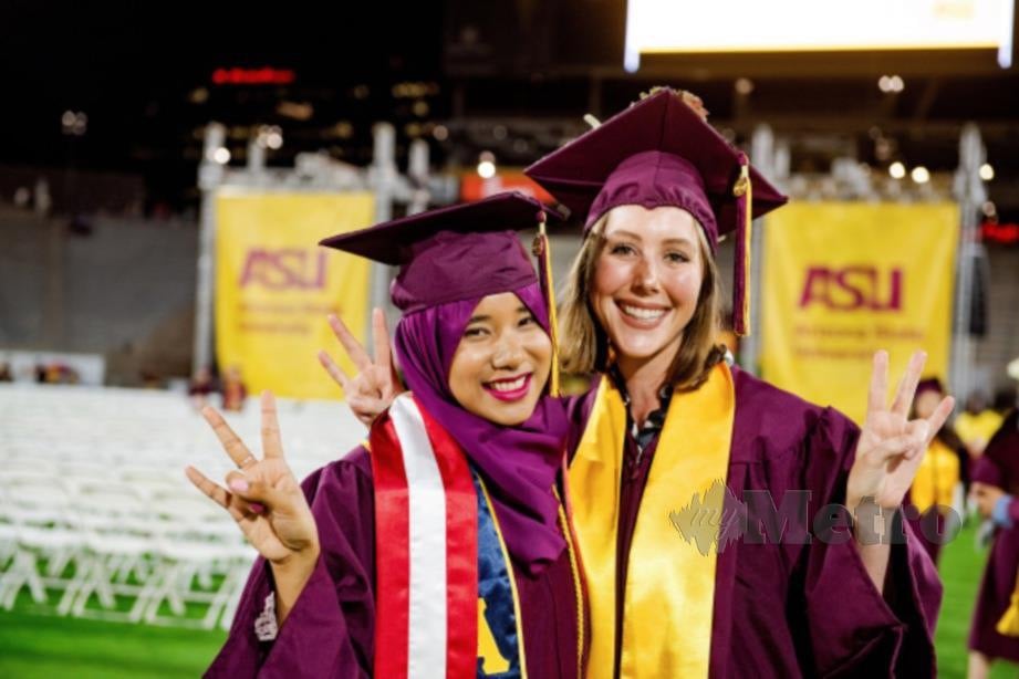 Maryam Balqis (kiri) bersama rakannya meraikan hari graduasi. FOTO Ihsan e-Warta Mara