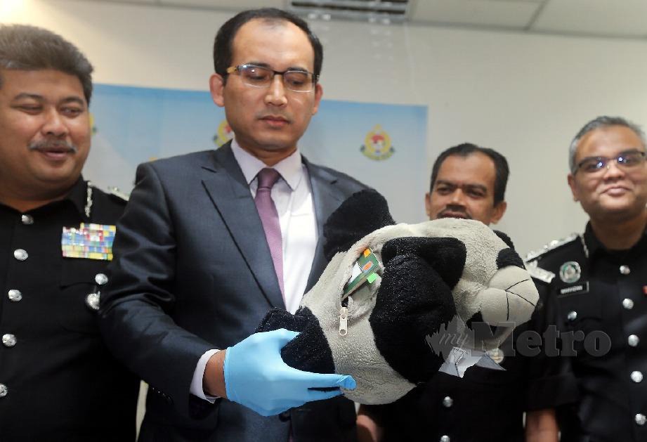 KHAIRUL Dzaimee menunjukkan pasport palsu disorokkan dalam patung panda yang cuba dilupuskan suspek.  FOTO Mohd Fadli Hamzah.