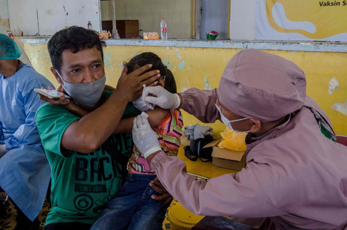 KANAK-KANAK menerima suntikan vaksin Covid-19 di Jogjakarta. FOTO AFP 