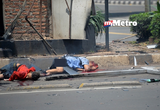 Dua mayat terbaring di jalan raya di luar pos polis yang duserang militan. - Foto  AFP 