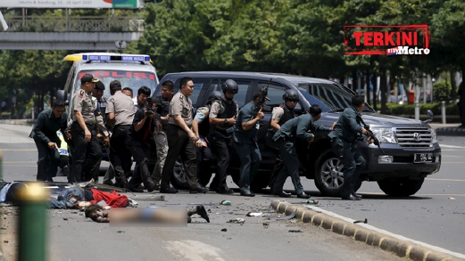 Mayat mangsa letupan terbaring di atas jalan ketika polis Indonesia mengambil kedudukan untuk menyerang militan. - Foto REUTERS/BEAWIHARTA