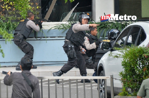 Polis Indonesia mengambil kedudukan ketika memburu lelaki bersenjata yang terbabit dalam serangan bom di sebuah bangunan menempatkan Starbucks di Jakarta. - Foto  AFP 