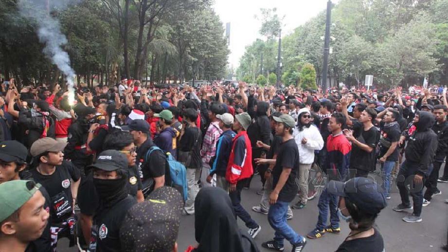 PENYOKONG Indonesia di luar stadium dengan menyalakan ‘flare’ merah. FOTO NSTP