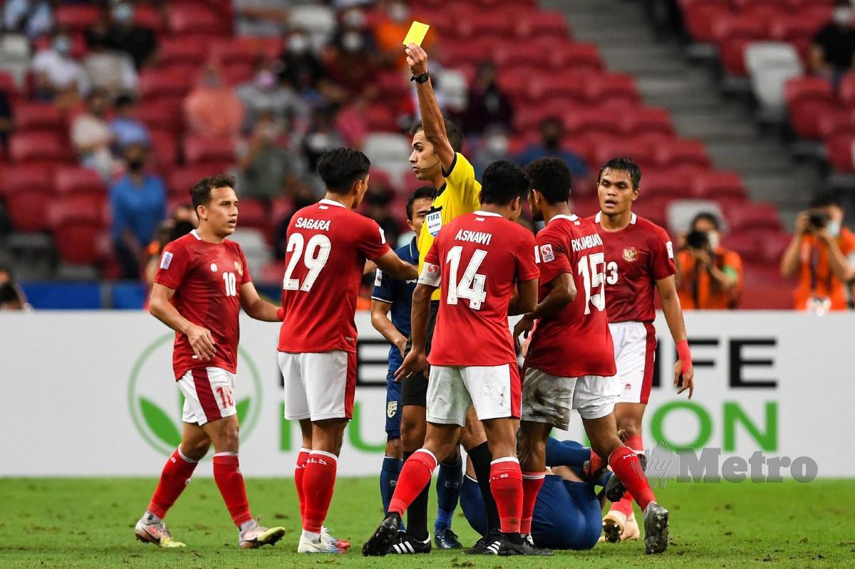 PEMAIN Indonesia Asnawi Mangkualam Bahar (tengah) menerima kad kuning pada aksi final kedua Piala AFF bertemu Thailand, malam tadi. FOTO AFP
