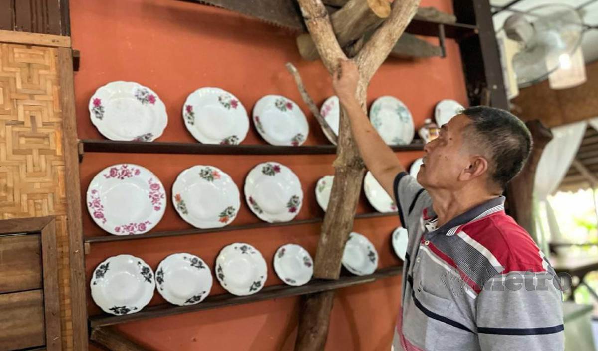 ZAKARIA menunjukan sebahagian koleksi barangan antik dan unik yang terdapat di kedainya di Taman Tasik Gua Musang. FOTO Paya Linda Yahya