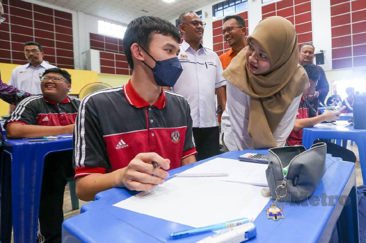 FADHLINA (kanan) beramah mesra dengan calon peperiksaan Sijil Pelajaran Malaysia (SPM) yang mengikuti kelas pembelajaran seperti biasa ketika lawatan kerja susulan gangguan bekalan air di SMK Seri Nibong, hari ini. FOTO Danial Saad