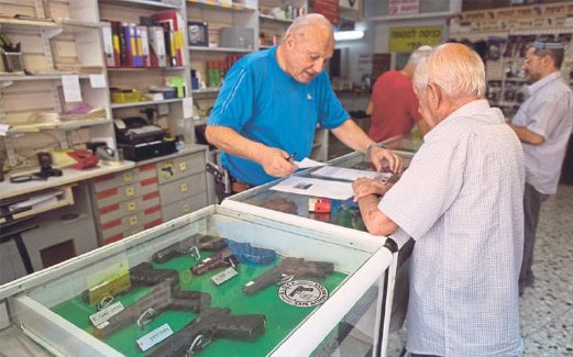 PENDUDUK Yahudi yang mendiami bumi Palestin membeli senjata di sebuah kedai di Baitulmaqdis.