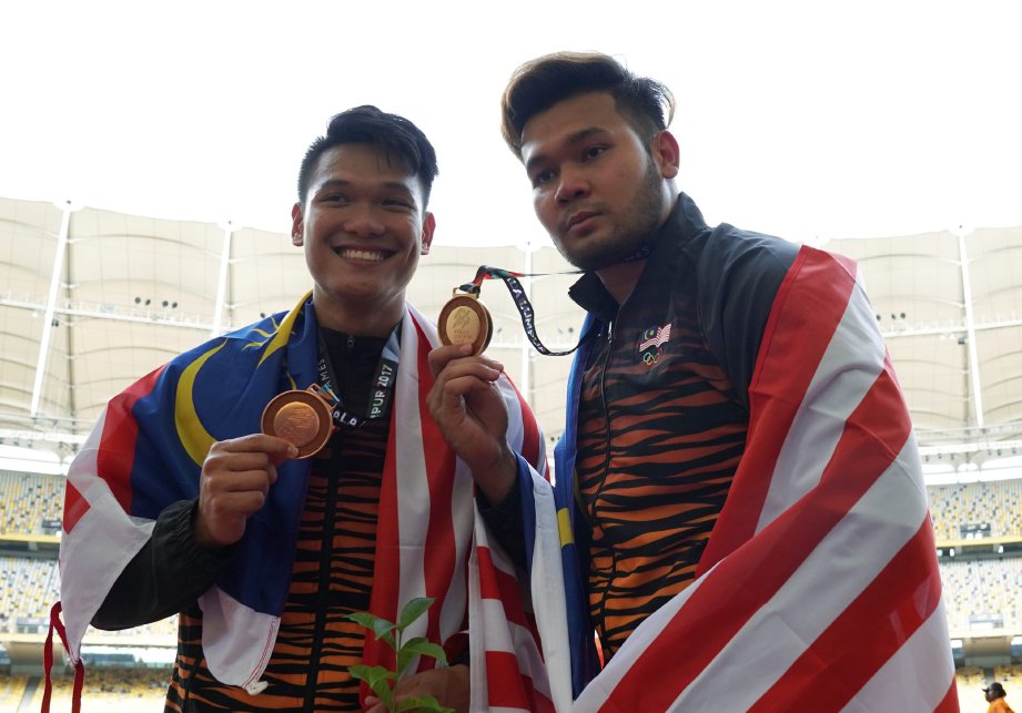 IRFAN yang memenangi pingat emas lempar cakera bersama Abdul Rahman Lee yang memenangi pingat gangsa (kiri). -Foto OSMAN ADNAN