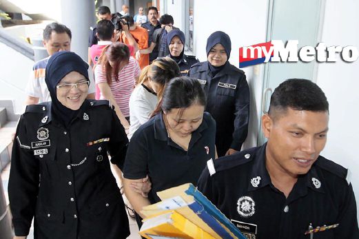 Anggota polis mengiringi tertuduh yang didakwa atas pertuduhan menculik bayi di Mahkamah Majistret 3, Kompleks Mahkamah Melaka, di Ayer Keroh, hari ini. FOTO Rasul Azli Samad