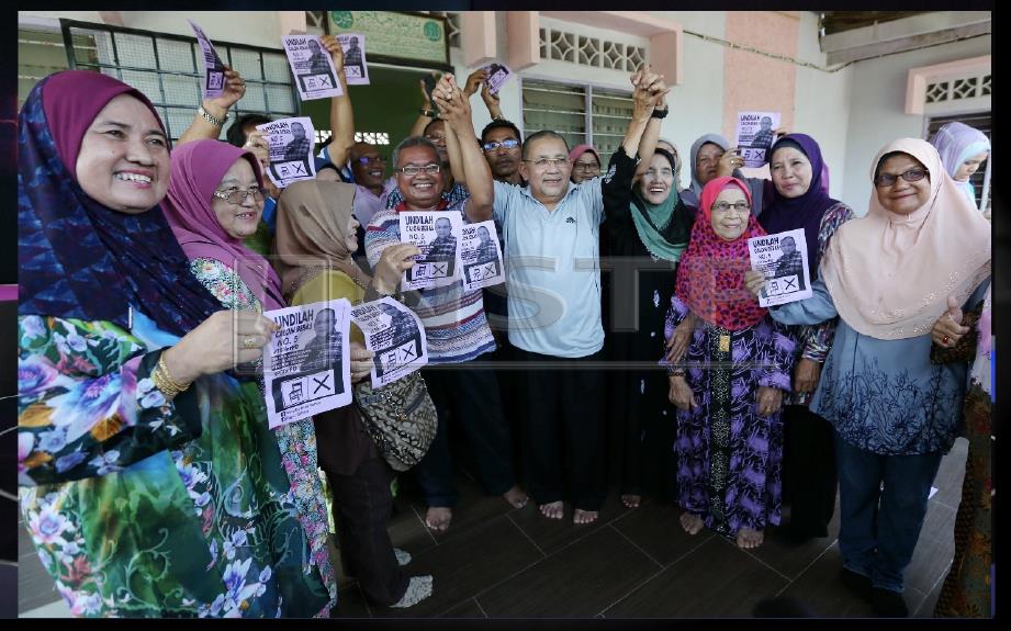 Mohd Isa melaungkan kata-kata semangat bersama penduduk setempat ketika berkempen sempena PRK Port Dickson di Kampung Bagan Pinang, Port Dickson. FOTO Iqmal Haqim Rosman 