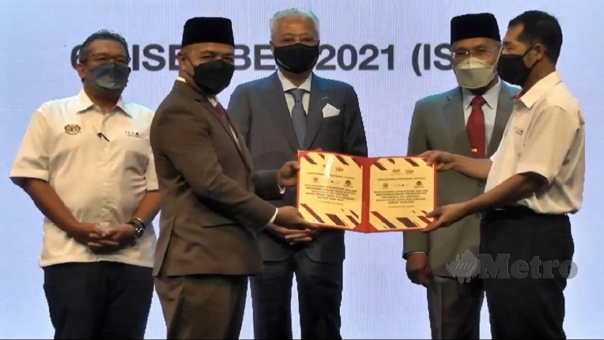 DATUK Seri Ismail Sabri Yaakob (tengah) menyaksikan salah satu MoU yang dimeterai pada majlis Tindakan Pembangunan Bumiputera 2030 (TPB2030) hari ini.