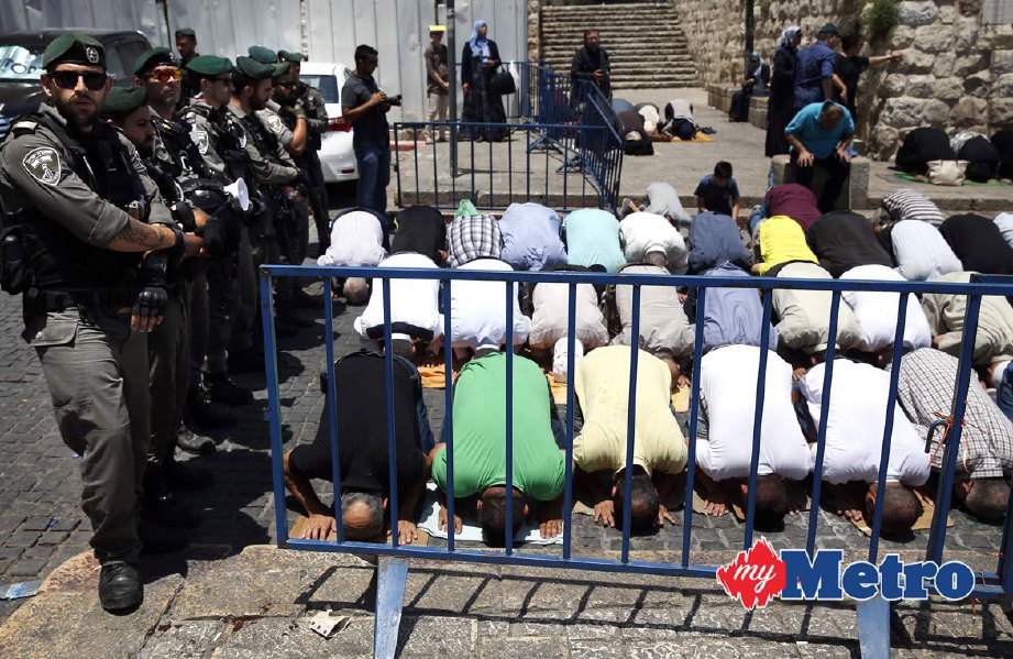 Askar Israel berkawal di kawasan luar pintu masuk utama Masjid al-Aqsa yang mana sekumpulan rakyat Palestin menunaikan solat selepas enggan menuruti peraturan Israel yang antaranya meletakkan pengesan logam di pintu masuk itu. FOTO AFP