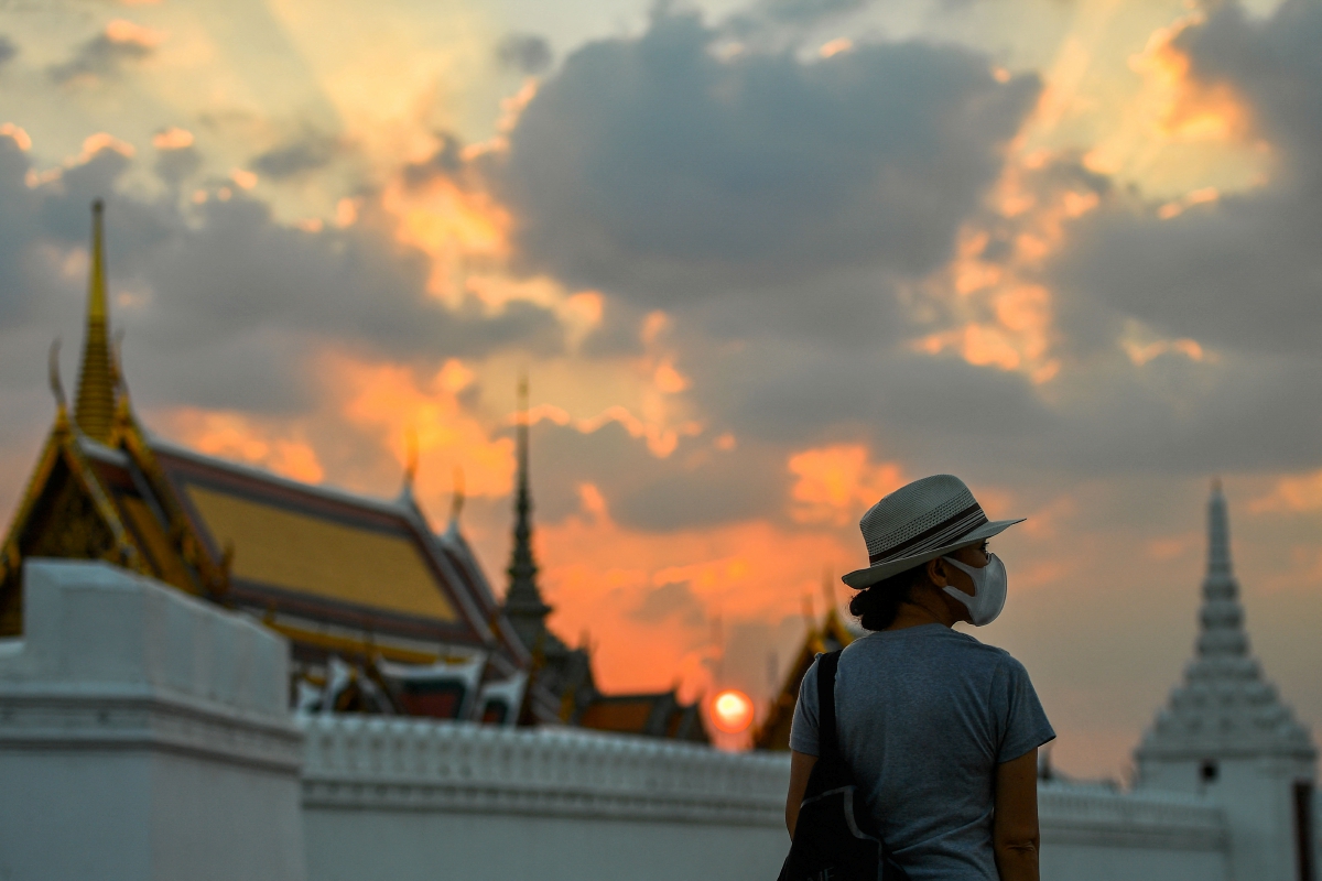 PELANCONG memakai pelitup muka ketika mengunjungi Grand Palace, Bangkok. FOTO Reuters
