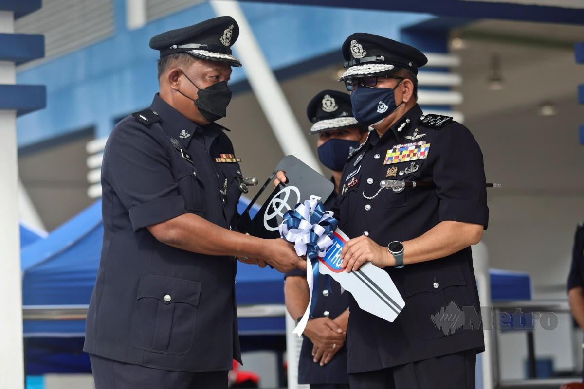 Mazlan (kanan) menyampaikan kunci kenderaan sebagai simbolik kepada Ketua Polis Daerah Hulu Terengganu, Deputi Superintendan Mohd Adli Mat Daud. FOTO GHAZALI KORI