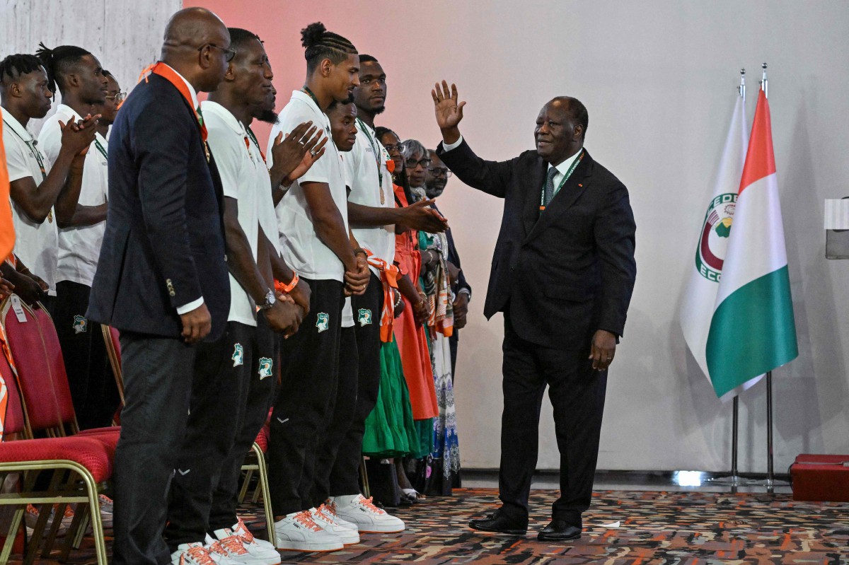 ALLASSANE Ouattara (kanan) mengucapkan tahniah kepada barisan pemain Ivory Coast yang muncul juara Piala Negara-Negara Afrika. FOTO AFP
