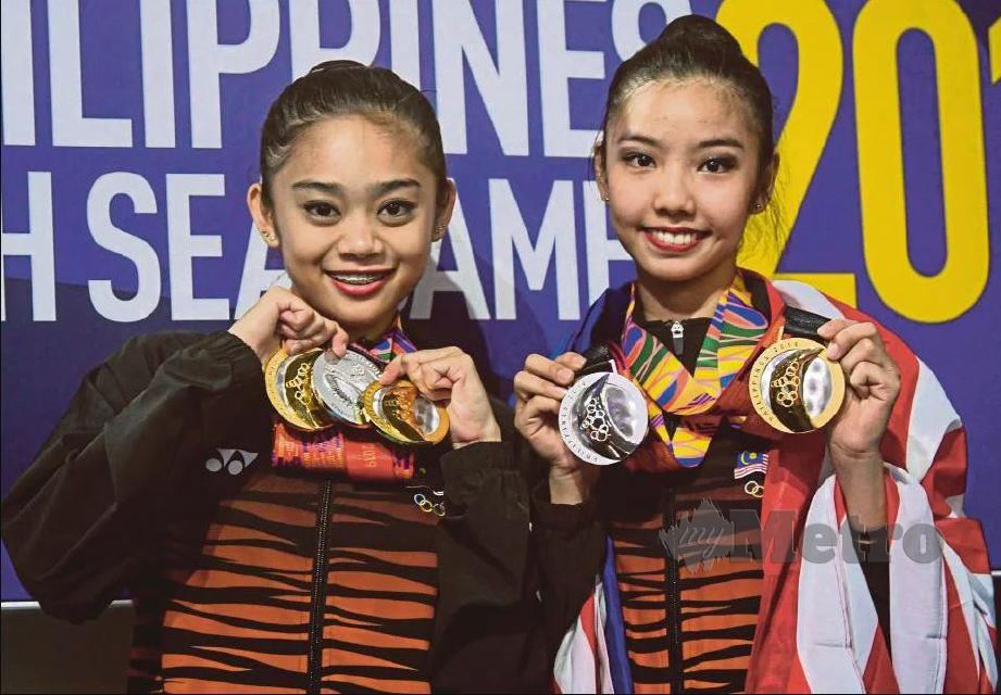 IZZAH (kiri) dan Koi Sie Yan menunjukkan pingat yang dimenangi pada Sukan SEA Manila 2019 di Kompleks Sukan Rizal Memorial. - FOTO Bernama