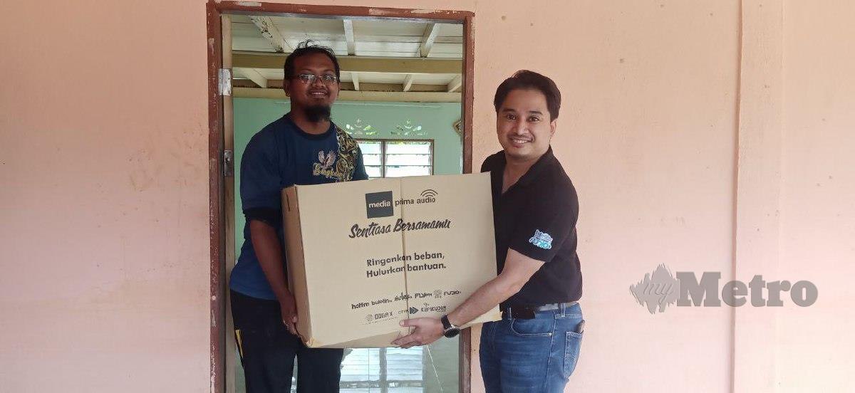 IZWAN menyampaikan kotak makanan kepada mangsa banjir di Kupang. FOTO SAFURI KAMARUDIN