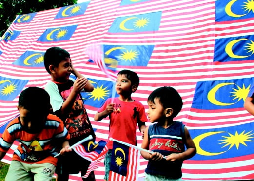  Kanak-kanak mengibarkan bendera Malaysia  berlatarbelakangkan Jalur Gemilang  gergasi di Taman Pulau Gadong Jaya. 