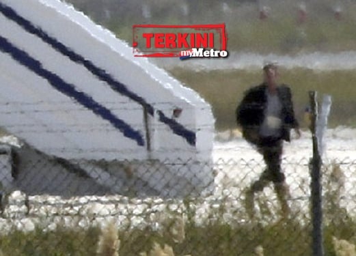 Perampas pesawat EgyptAir berjalan meninggalkan pesawat sebelum dia ditahan anggota keselamatan Cyprus. - Foto REUTERS