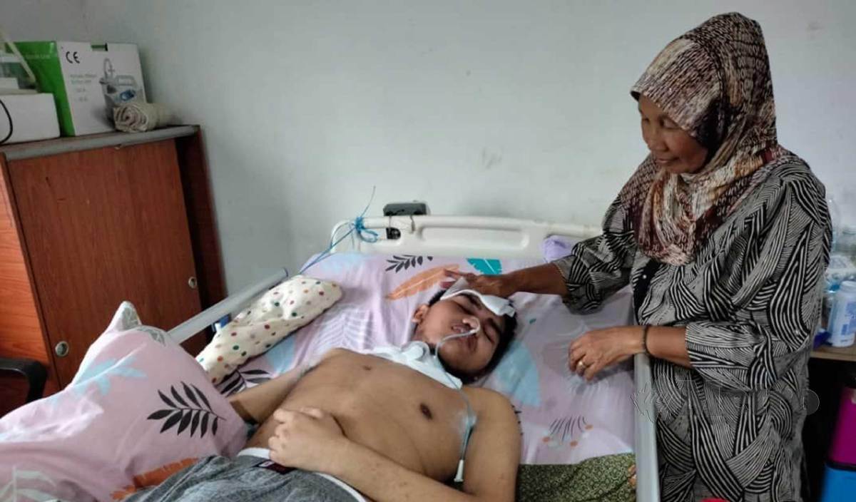KAMARIAH menjaga cucu, Muhammad Nabil Haikal yang terlantar akibat kemalangan jalan raya. FOTO Amirul Aiman Hamsuddin