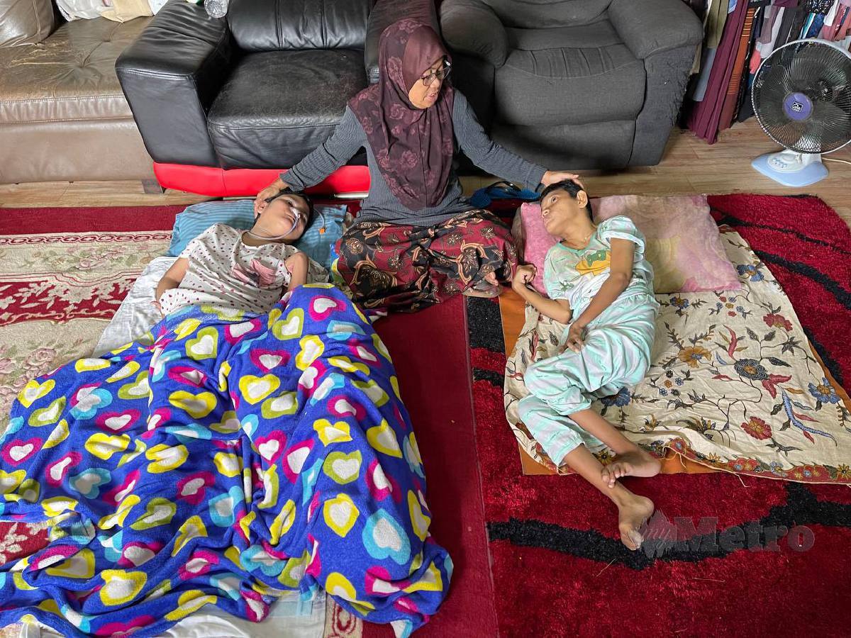 Umi Kalsum tabah menguruskan anaknya, Norjan (kiri) dan adik bongsunya, Ainul Nadiah yang menghidap penyakit cerebral palsy dirumahnya di Kampung Kuala Juru, Bukit Mertajam. FOTO Nur Izzati Mohamad