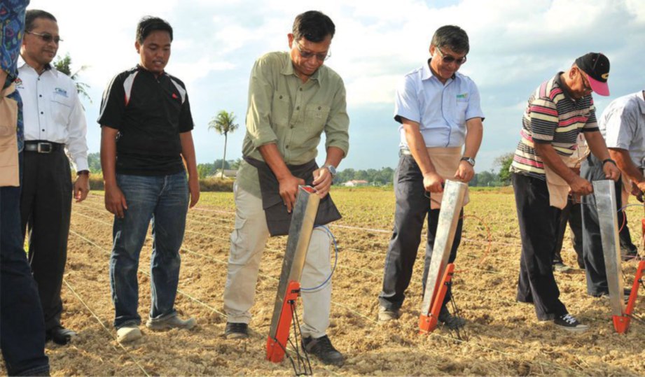 MENTERI Pertanian dan Industri Asas Tani Datuk Seri Ahmad Shabery Cheek menggunakan alatan japper untuk menanam jagung bijirin di Kampung Dadong, Kemaman, Terengganu.