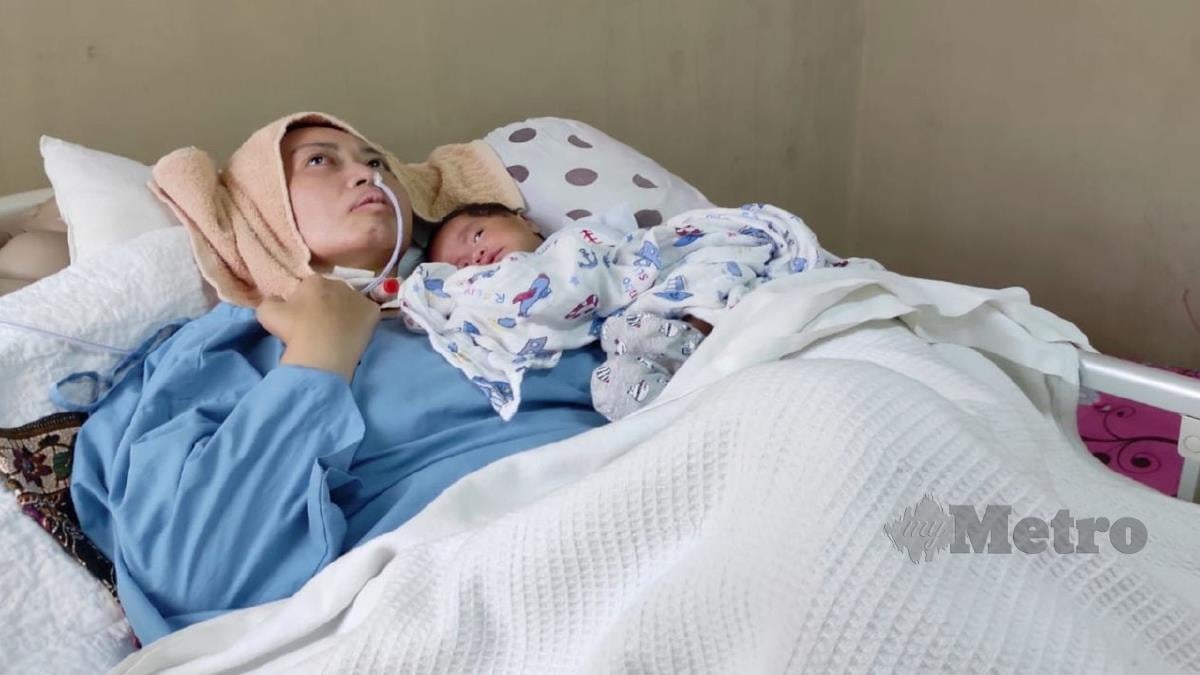 JAHIDAH bersama anaknya masih dalam keadaan terlantar di katil. FOTO Ihsan Fauziah Nordin.