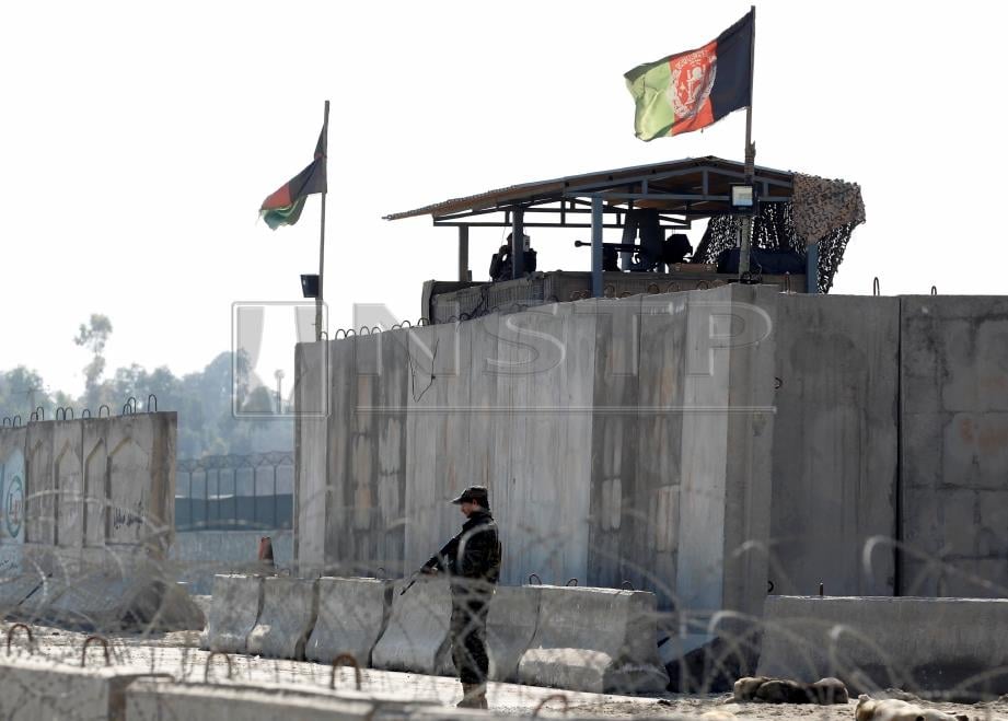 PASUKAN keselamatan Afghanistan berdiri di tempat kejadian serangan di Jalalabad, Afghanistan. - Foto REUTERS