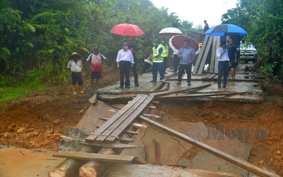 DOUGLAS Uggah (tiga kiri) meninjau Jambatan Ulu Rimbas Asal yang runtuh selepas banjir, semalam. FOTO Ihsan DCMO.