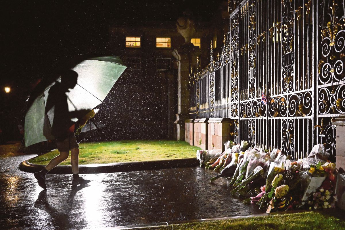 LELAKI meletakkan jambangan bunga di luar pintu Istana Hillsborough yang menjadi kediaman apabila Elizabeth berada di Ireland Utara. FOTO Reuters 