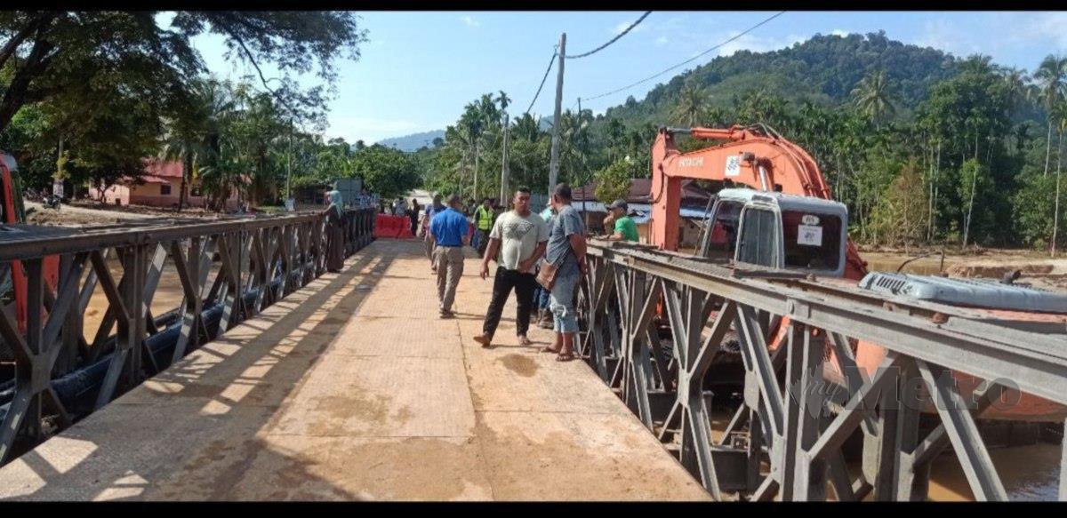Penduduk menggunakan Jambatan Bailey yang dibina sementara di Kampung Iboi untuk berulang alik setiap hari ke tempat kerja. FOTO SAFURI KAMARUDIN
