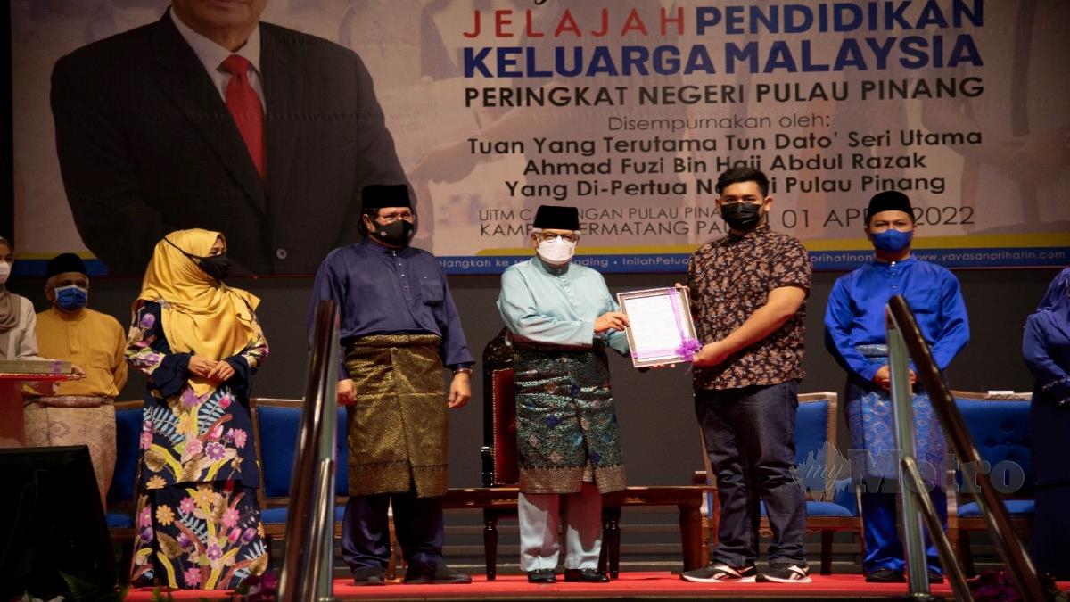 Ahmad Fuzi (tengah) menyerahkan surat tawaran kepada seorang pelajar anak Pulau Pinang pada Majlis Perasmian Jelajah Pendidikan Keluarga Malaysia di Permatang Pauh hari ini. 