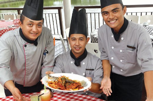 DARI kiri Mohd Hasraf Zahari, Faridzuan Ab Hadi dan Tuan Shafiq Tuan Suharto bersama hidangan makanan laut yang disediakan di restoran D’Tasik.