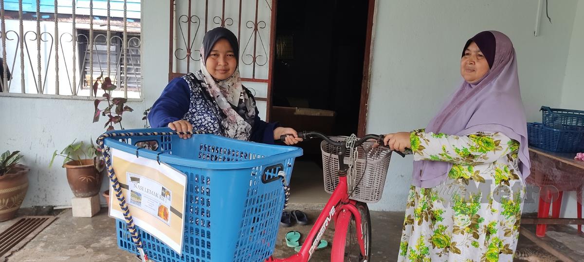 Saripah bersama basikal yang ditunggangnya setiap hari bagi menjual nasi lemak di hadapan Masjid Jamek Tanjung Malim. FOTO ROSMAN SHAMSUDIN