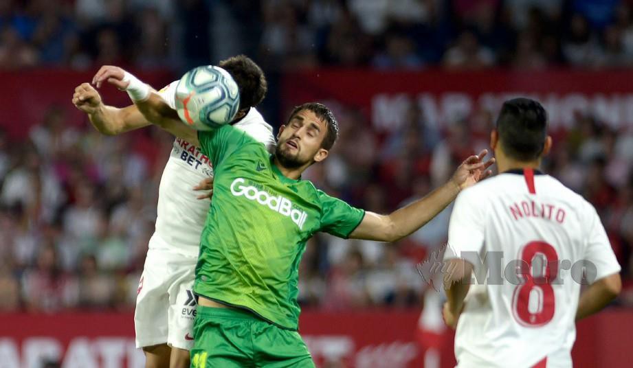Penyerang Real Sociedad, Adnan Januzaj (tengah) mengawal bola daripada pemain Sevilla. FOTO AFP