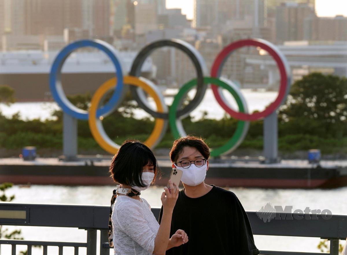 SEPASANG kekasih berswafoto berlatar belakang Logo Olimpik. FOTO EPA