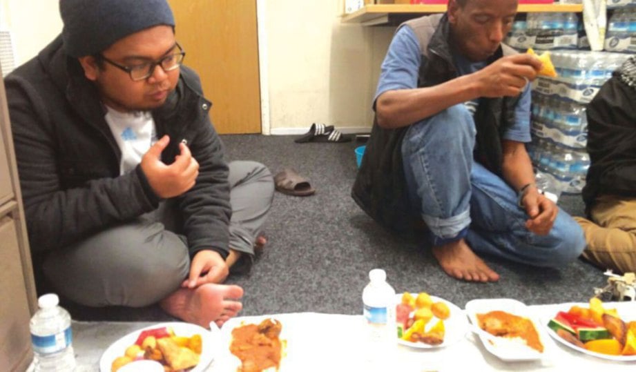 IRFAN (kiri) berbuka bersama orang Somalia di sebuah masjid di Liverpool.