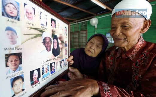 SULAIMAN dan Eshah  melihat gambar  17 anaknya di rumah mereka  di Kampung Kuala Merah, Kuala Ketil.