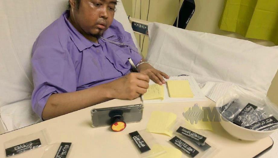 MOHD Izzuddin yang menghidap kanser limfoma gigih menyiapkan tempahan tag nama tulisan khat dari katil hospital.
