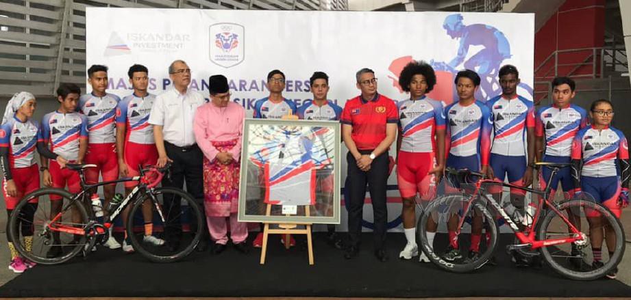 Khairil Anwar (lima kiri), Presiden Persatuan Berbasikal Negeri Johor, Datuk Amran A. Rahman (enam kiri) dan Gadaffie (enam kanan) bergambar bersama Iskandar Johor Cycling Team.