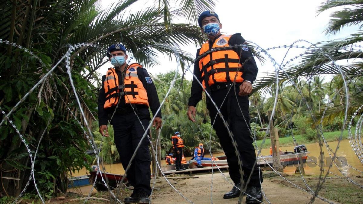 MOHD Rudzuan (kanan) bersama anggotanya memantau sekitar tiga kilometer (km) kawasan PKPD Mukim Sungai Pinang. FOTO Nik Abdullah Nik Omar. 