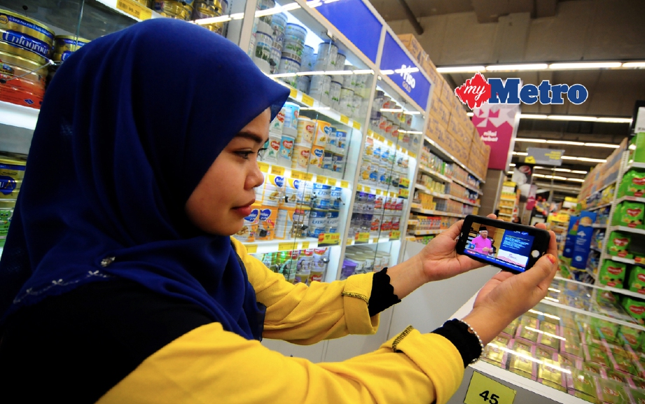 Pekerja pusat membeli belah, Nur Aini Raihan Shamsudin, 26, turut menonton siaran langsung pembentangan Bajet 2017  menerusi telefon bimbit. - Foto BERNAMA