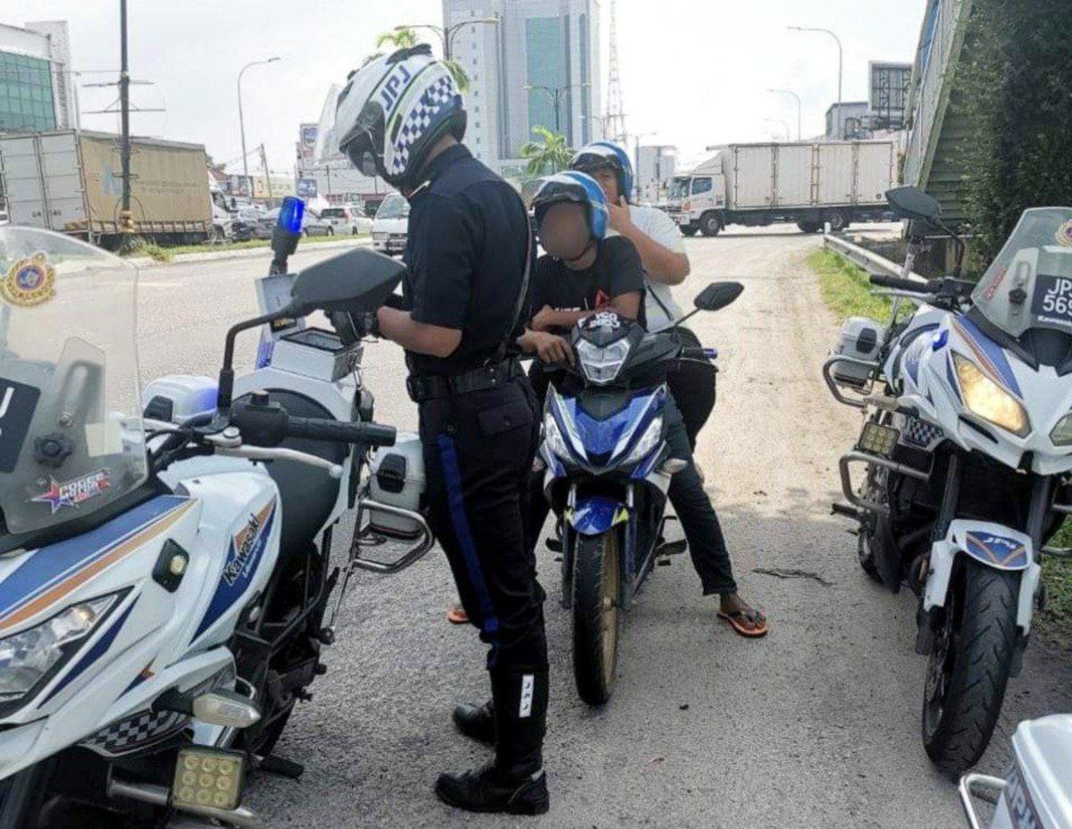 Anggota Jabatan Pengangkutan Jalan (JPJ) Pahang melakukan pemeriksaan terhadap penunggang motosikal pada operasi hari raya Aidilfitri. FOTO Ihsan JPJ