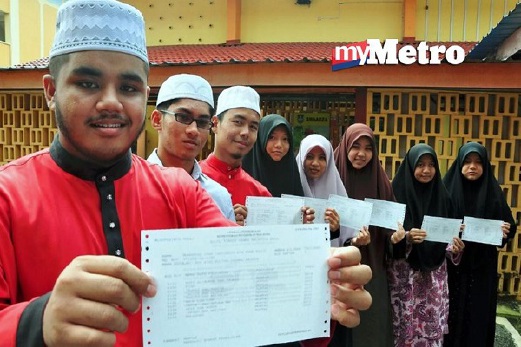 MUHAMMAD Iman Taqiuddin Mohd Razif (kiri) bersama pelajar terbaik yang lain menunjukkan slip peperikasan Sijil Tinggi Agama Malaysia (STAM) masing-masing ketika ditemui di SMA Atas Sultan Zainal Abidin (SMAZA). FOTO Syahirah Abdullah