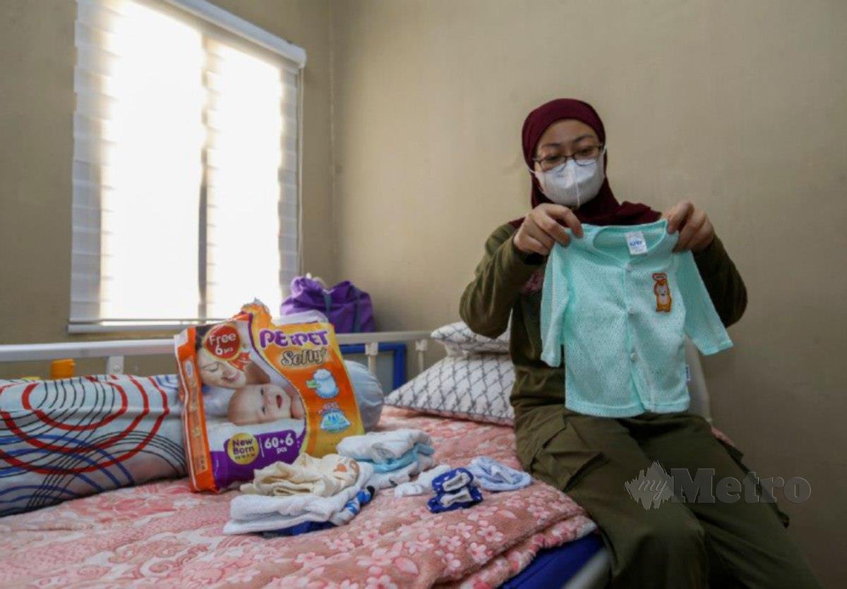 FAZARIAH membuat menyediakan pakaian bayi untuk kakaknya yang melahirkan anak secara pembedahan malam tadi. FOTO Azrul Edham Mohd Aminuddin