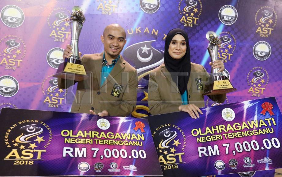 AZIZUL (kiri) dan Siti Rahmah memperagakan trofi dan hadiah sebagai Olahragawan, Olahragawati Terengganu 2018, malam ini. — FOTO Imran Makhzan